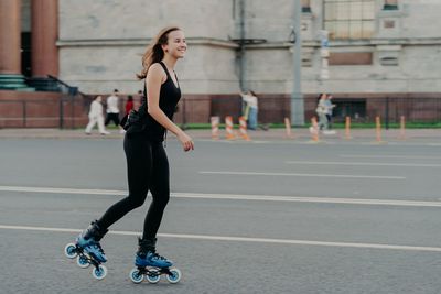 Full length side view of a woman skateboarding