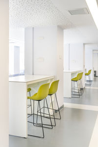 Empty chairs and table against wall