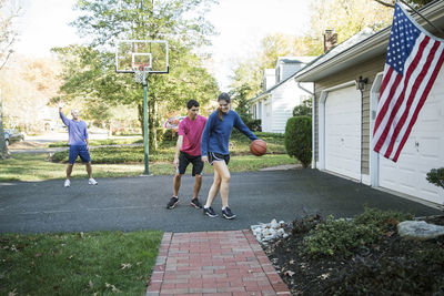 Happy family playing basketball at backyard