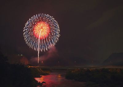 Firework display over river at night