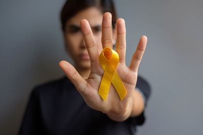 Close-up of woman holding yellow flower