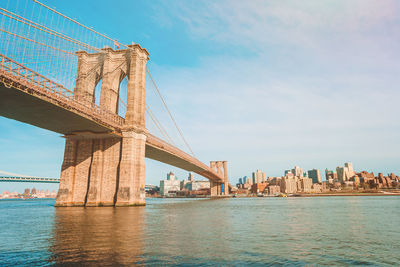 Low angle view of bridge over river against sky