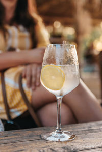 Close-up photo of refreshing lemonade in wine glass on table in beach bar