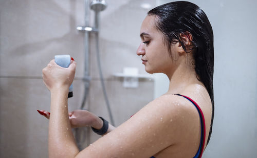 Side view of young woman exercising at home