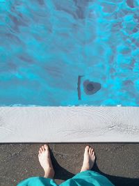 Low section of man relaxing in swimming pool