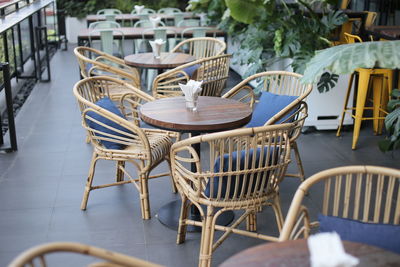 Empty chairs and tables at sidewalk cafe