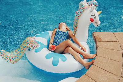 High angle view of boy sitting in swimming pool