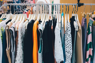 View of various clothes hanging for sale at market