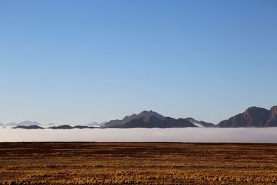 Scenic view of snowcapped mountains against clear blue sky