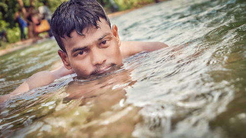 Tilt shot of man swimming in lake