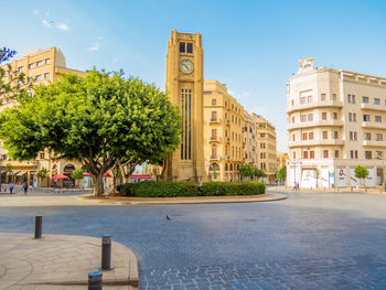 Street by buildings against sky in city