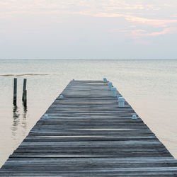 Pier over sea against sky during sunset