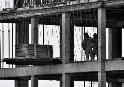 Low angle view of men working against building