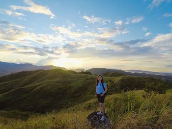 Rear view of woman standing on mountain against sky