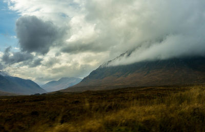 Scenic view of mountains against cloudy sky