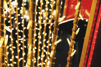 Low angle view of illuminated light bulbs hanging from ceiling