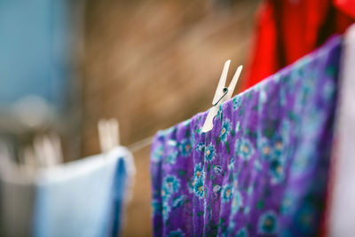 Close-up of multi colored clothes hanging on blue wall