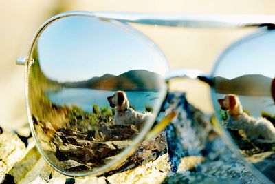 Close-up of sunglasses in lake against sky