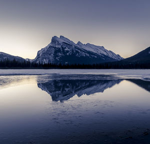 Scenic view of frozen lake and mountains against sky 