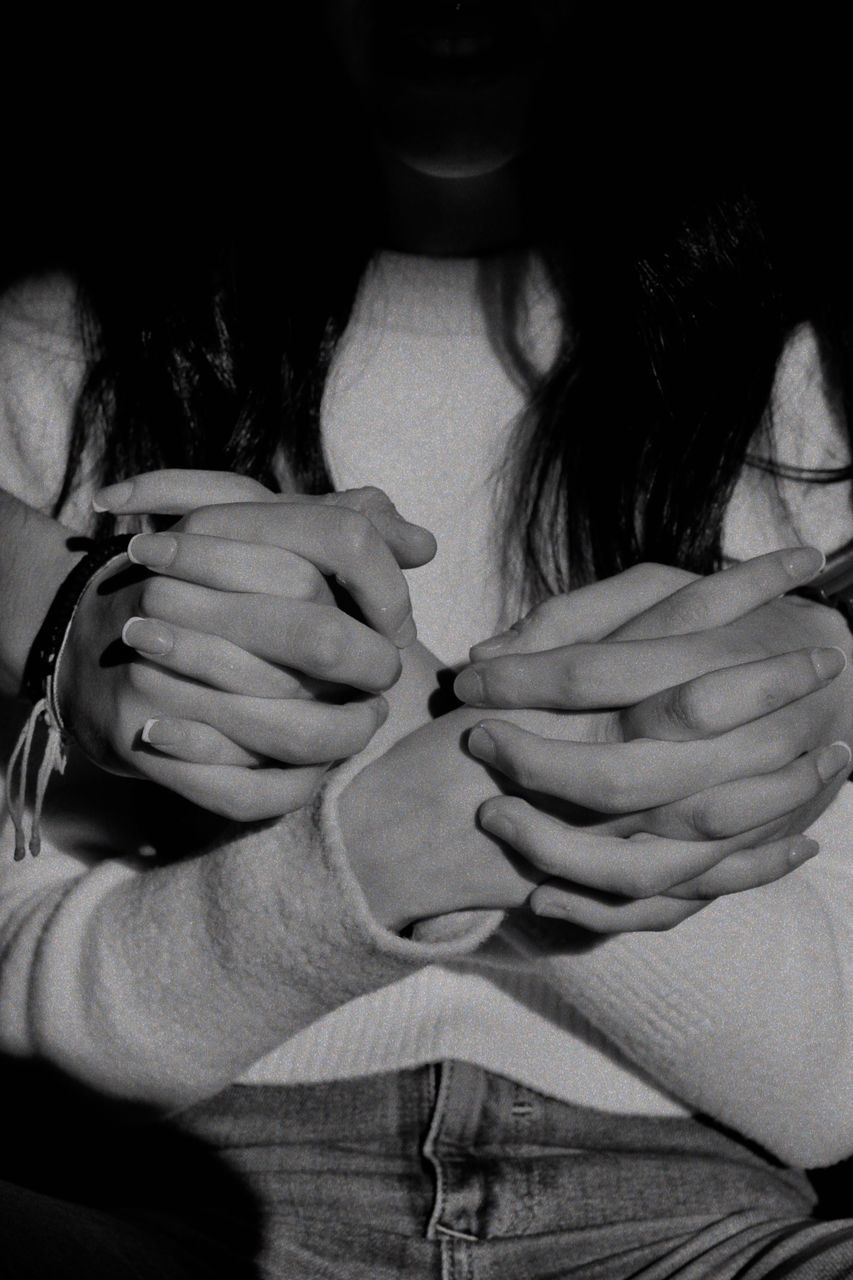 CLOSE-UP OF WOMAN HOLDING HANDS WITH HAIR