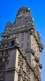 Low angle view of old building against clear blue sky