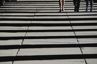 Low section of woman walking on footpath