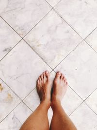 Low section of woman standing on tiled floor