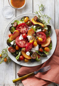 Summer fruit salad with dressing and greens