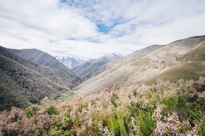 Scenic view of mountain range against cloudy sky