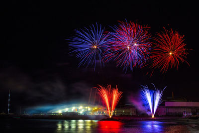 Firework display over river at night