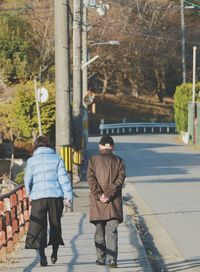 Rear view of men walking on tree