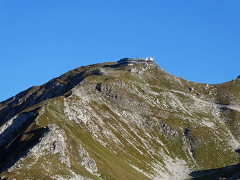 Low angle view of mountain against clear blue sky