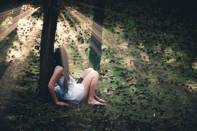 Side view of woman sitting on field