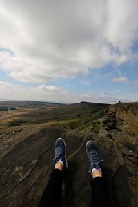 Low section of man on mountain against sky