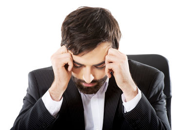 Young man making face against white background
