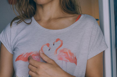 Midsection of woman holding heart shape