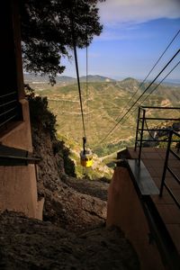 Low angle view of overhead cable car against sky