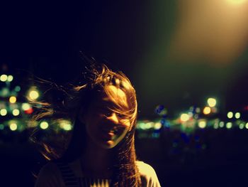 Portrait of woman with illuminated hair at night