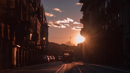 Cars on road against sky during sunset