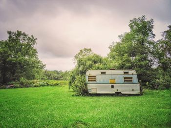 Vintage camper on field against sky