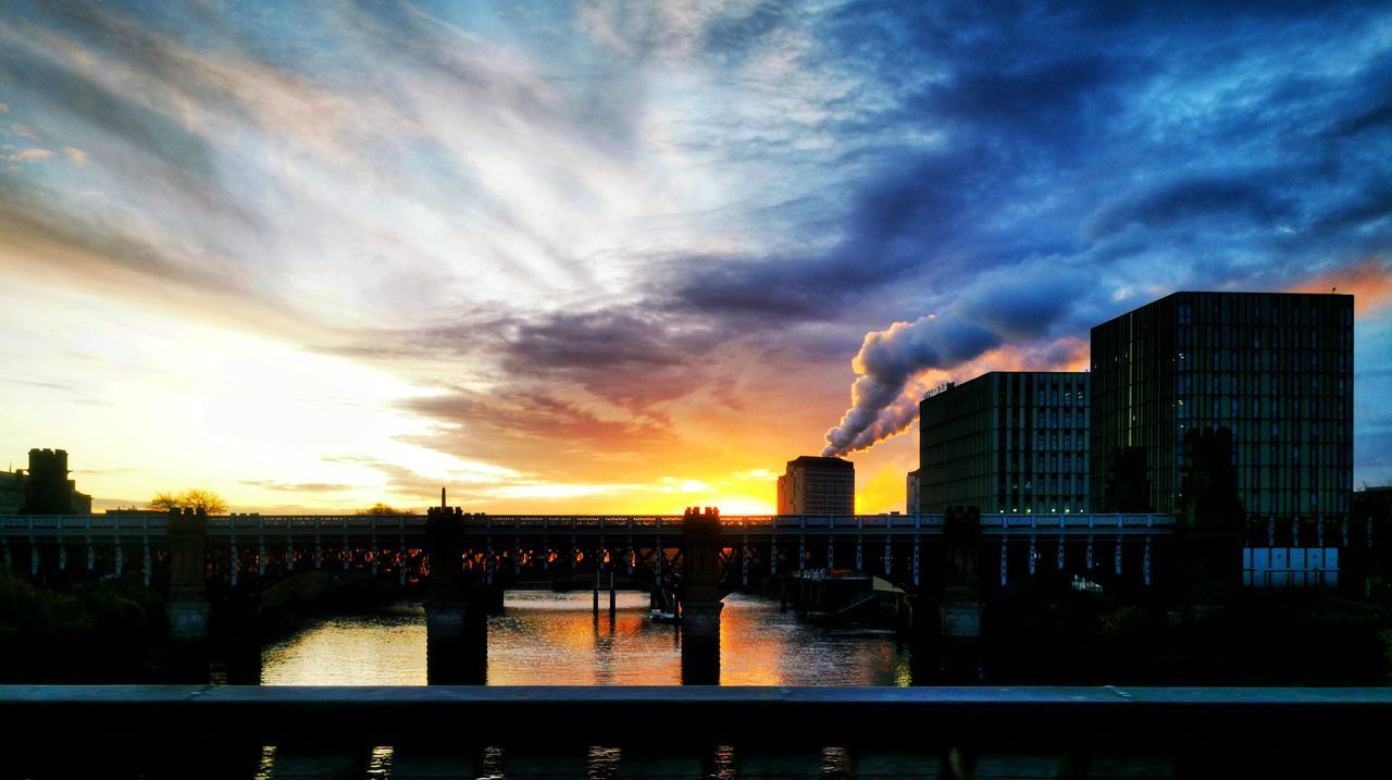 BRIDGE OVER RIVER AGAINST BUILDINGS IN CITY