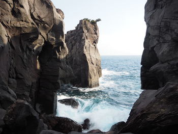 Scenic view of sea and rock formation against sky