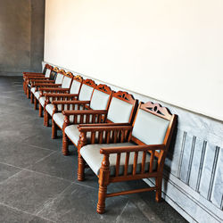 Empty chairs and tables against building