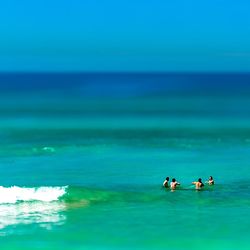 Friends swimming in sea against sky