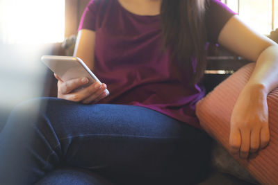 Midsection of woman using mobile phone
