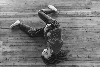 High angle portrait of man lying on hardwood floor