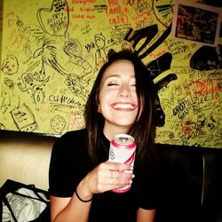 Portrait of smiling young woman holding camera