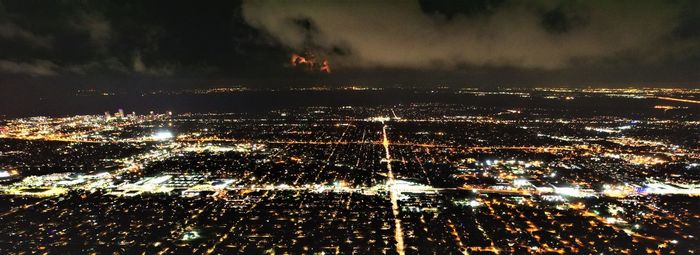 High angle view of illuminated cityscape against sky at night