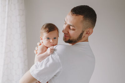 Father holding baby at home