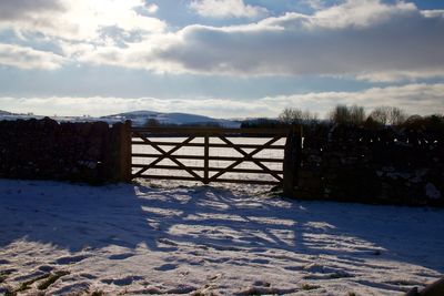 Snow covered field against sky